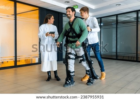 Mechanical exoskeleton, female doctor with device walking with man with a disability with robotic skeleton in rehabilitation, physiotherapy in modern hospital, futuristic physiotherapy