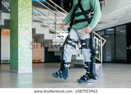 Mechanical exoskeleton, unrecognizable man with a disability walking with the help of robotic skeleton, physiotherapy in a modern hospital, futuristic physiotherapy