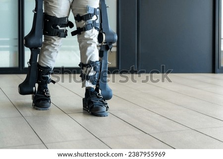 Mechanical exoskeleton, unrecognizable man with a disability walking with the help of robotic skeleton, physiotherapy in a modern hospital, futuristic physiotherapy