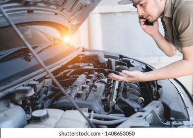 Mechanical Fixing Car At Home. Repairing Service Advice By Mobile Phone. Mechanic, Technician Man Checking Car Engine. Car Service, Repair, Fixing, Maintenance Working Inspection Vehicle Concept.