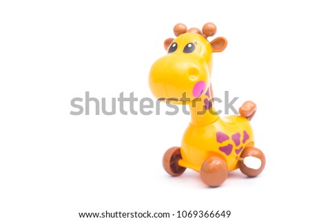 Mechanical giraffe toy. Clockwork plastic toy isolated on right hand with white background.
