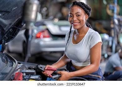 Mechanical Girl At Car Repair Shop Stand Hold Battery Jumper Cable Red And Black For Polarity Negative And Positive DC Volt