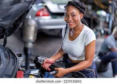 Mechanical Girl At Car Repair Shop Stand Hold Battery Jumper Cable Red And Black For Polarity Negative And Positive DC Volt