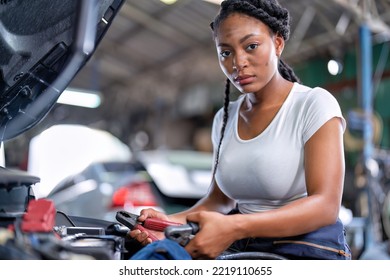 Mechanical Girl At Car Repair Shop Stand Hold Battery Jumper Cable Red And Black For Polarity Negative And Positive DC Volt