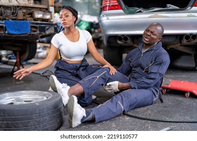 Mechanical Guy At Car Repair Shop Got Accident Sit On The Floor Mechanical Girl First Aid Check His Broken Leg Painful And Emergency Call For Help