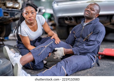 Mechanical Guy At Car Repair Shop Got Accident Sit On The Floor Mechanical Girl First Aid Check His Broken Leg Painful And Emergency Call For Help