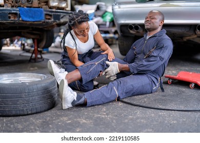 Mechanical Guy At Car Repair Shop Got Accident Sit On The Floor Mechanical Girl First Aid Check His Broken Leg Painful And Emergency Call For Help