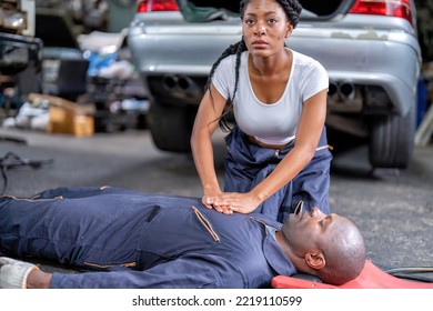 Mechanical Guy At Car Repair Shop Got Accident Lay On The Floor Mechanical Girl First Aid Life Saving By Perform Cardiopulmonary Resuscitation CPR Before The Medic Come