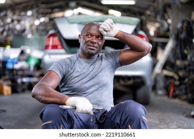 Mechanical Guy At Car Repair Shop Sitting Clean Up Sweat From His Head And Blow Air From Mouth