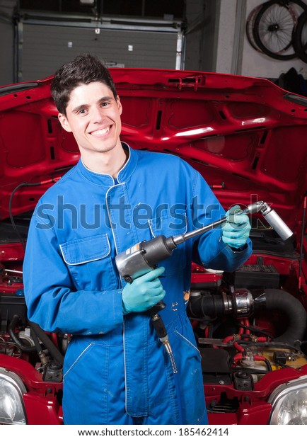 Mechanical smiling\
and holding a tool in a\
garage