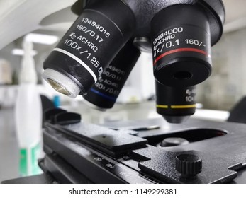 Mechanical stage and objective lenses, parts of a high-tech microscope with detailed marks, 100X, 40X, 10X and 4X with a scientific laboratory background - Powered by Shutterstock - Get 15% off with code: PIKWIZARD15