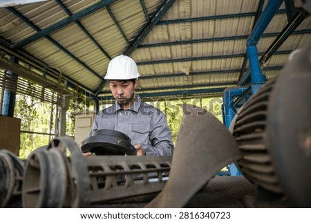 Mechanical Technician Checking Pump Machinery During Routine Maintenance at Utility Facility