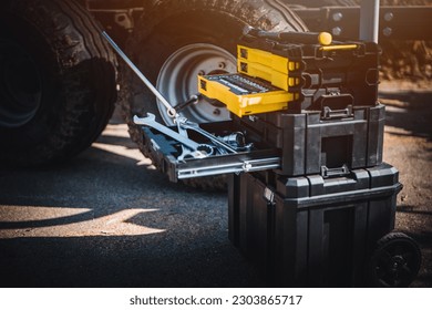 Mechanical tools box. Worker using different repair tools for repairing and service. Tool set near the auto. Closeup. Automobile servicing and repair concept.