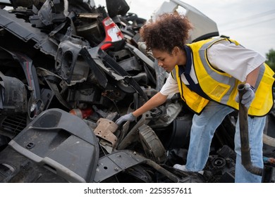 Mechanical woman owner small business inspecting standing in the car junkyard, Dirty male repairman choosing spare parts on car junkyard, Used of vehicle part for recycling in the scrap yard garage. - Powered by Shutterstock