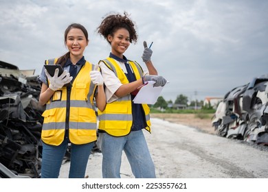 Mechanical woman owner small business inspecting standing in the car junkyard, Dirty male repairman choosing spare parts on car junkyard, Used of vehicle part for recycling in the scrap yard garage. - Powered by Shutterstock