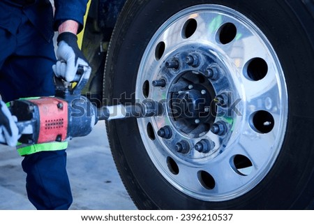 Mechanical workshop operator changing the front wheel of a truck