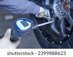 Mechanical workshop. Operator measuring the pressure of a tire inside a workshop.