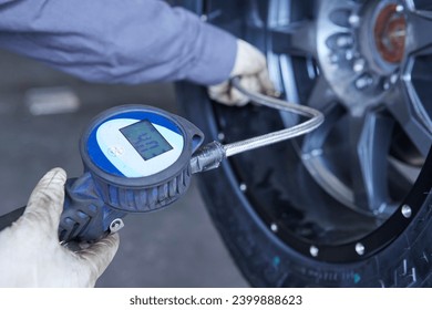 Mechanical workshop. Operator measuring the pressure of a tire inside a workshop.