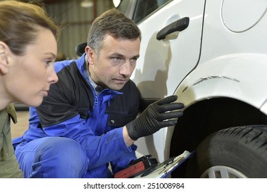 Mechanician With Insurance Adjuster Checking On Auto Repair