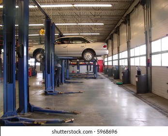 Mechanics Garage With Car On Hoist