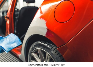 Mechanic's garage. Process of car damage repair. Red car covered with automotive filler and being prepared for varnishing. High quality photo - Powered by Shutterstock