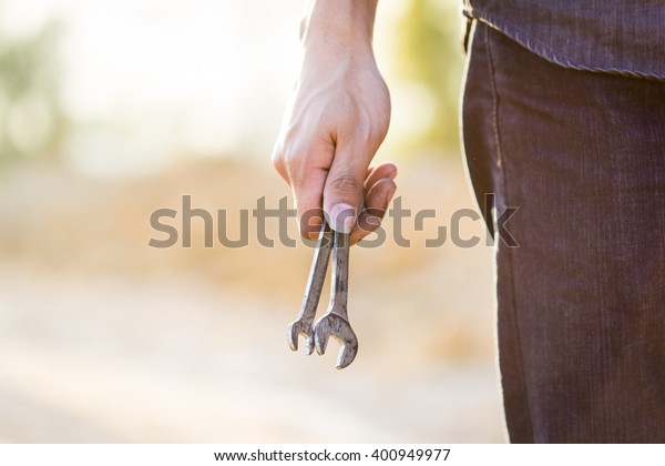 Mechanic\'s hand holding a\
wrench