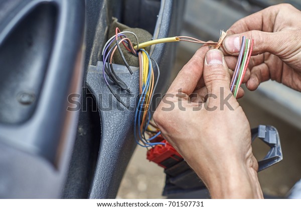  Mechanic\'s hands repairing\
electrical wires in the door of old car                            \
 