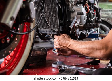 Mechanic's Hands Repairing The Motorcycle Breakdown In The Repair Shop