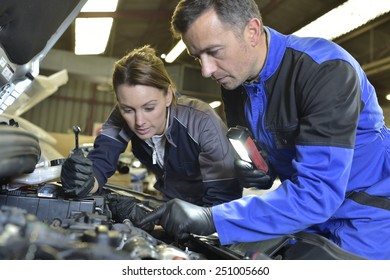 Mechanics Instructor Teaching Woman In Apprenticeship