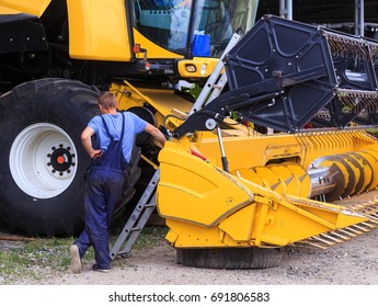 The Mechanics Repair The Yellow Combine Harvester In The Farm Yard. Concept Theme Repair, Mechanics, Production, Industry, Agribusiness, Production Of Food, Agricultural Production. Not Staged Photo.