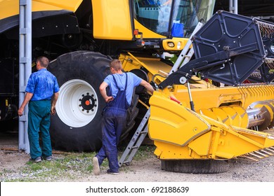 The Mechanics Repair The Yellow Combine Harvester In The Farm Yard. Concept Theme Repair, Mechanics, Production, Industry, Agribusiness, Production Of Food, Agricultural Production. Not Staged Photo.