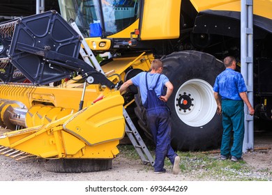 The Mechanics Repair The Yellow Combine Harvester In The Farm Yard. Concept Theme: Repair, Mechanics, Production, Industry, Agribusiness, Production Of Food, Agricultural Production.