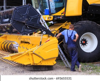 The Mechanics Repair The Yellow Combine Harvester In The Farm Yard. Concept Theme: Repair, Mechanics, Production, Industry, Agribusiness, Production Of Food, Agricultural Production.