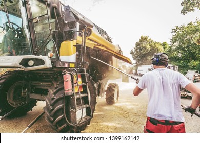 The Mechanics Repair The Yellow And Green Combine Harvester In The Farm Yard. 