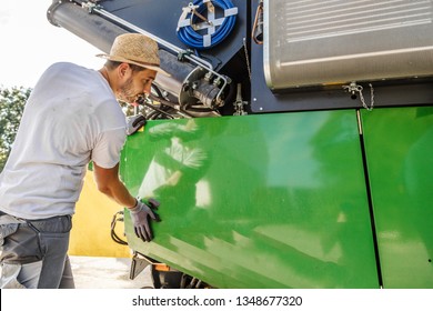 The Mechanics Repair The Yellow And Grrem Combine Harvester In The Farm Yard. 