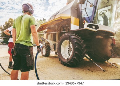 The Mechanics Repair The Yellow And Grrem Combine Harvester In The Farm Yard. 