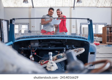 Mechanics restoring vintage cars in workshop - Powered by Shutterstock