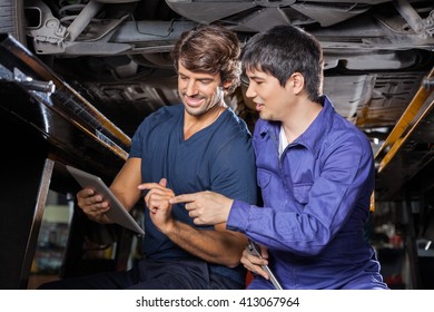 Mechanics Using Tablet Computer Under Lifted Car - Powered by Shutterstock - Get 15% off with code: PIKWIZARD15