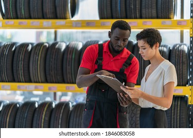 A Mechanic/service Engineer Working In Tires Shop Helping Customer To Select The Tire