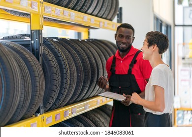 A Mechanic/service Engineer Working In Tires Shop Helping Customer To Select The Tire