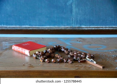 Mechanicville, NY/USA- December 8, 2018: A horizontal image of wooden rosary beads and a red Bible on a wooden desk at an abandoned Catholic church in upstate NY.                                 