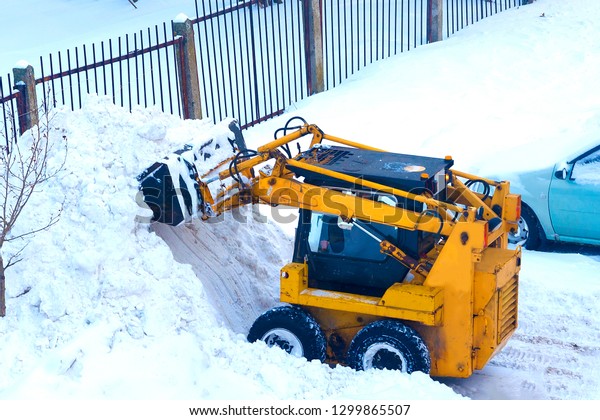 Mechanized snow\
cleaning compact road equipment. concept: heavy snowfall, the work\
of communal services. soft\
focus.