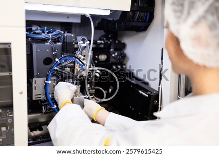Mechatronics engineer standing by prototype machine in research and development factory.