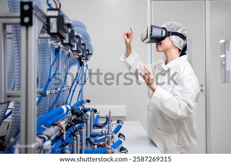 Mechatronics engineer using VR glasses to visualize prototype machine in research and development factory.