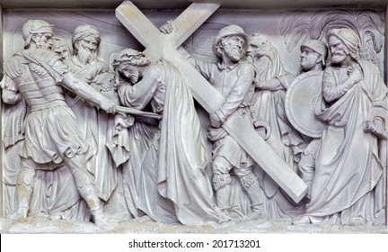 MECHELEN, BELGIUM - JUNE 14, 2014: Stone relief Simon of Cyrene help Jesus to carry his cross  in church Our Lady across de Dyle. 
