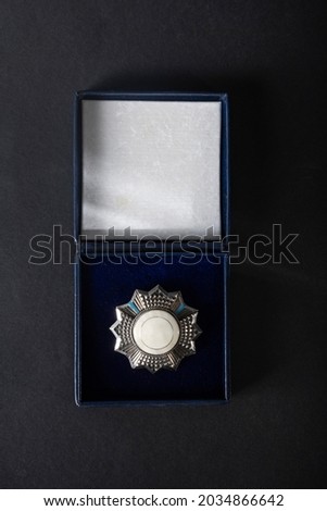 Medal, insignia, in an open box on black velvet, on a dark background