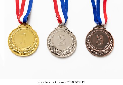 Medals Set, Gold, Silver And Bronze. Winners, Athletes Podium Prize Trophy Concept. First, Second And Third Place Award Hanging From Red Blue Ribbon Isolated On White Background.