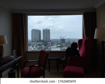 Medan, North Sumatra-2020: A Young Lady Enjoys The The View At The Window Of A Five Star Hotel In Medan. During The New Normal, People Might Will Still Choose To Not Going Out Frequently.