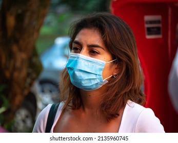 Medellin, Antioquia, Colombia - February 19 2022: Young South American Woman Dressed In White Is Listening Attentively At The Meeting In The Street