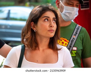 Medellin, Antioquia, Colombia - February 19 2022: Young South American Woman Dressed In White Is Listening Attentively At The Meeting In The Street